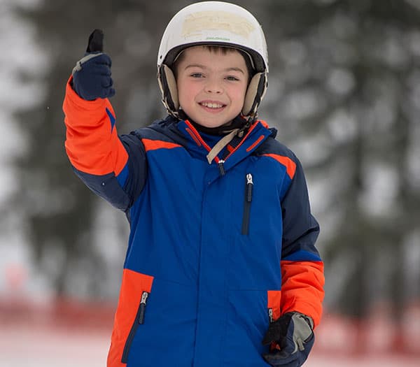 Kid with helmet on giving thumbs up
