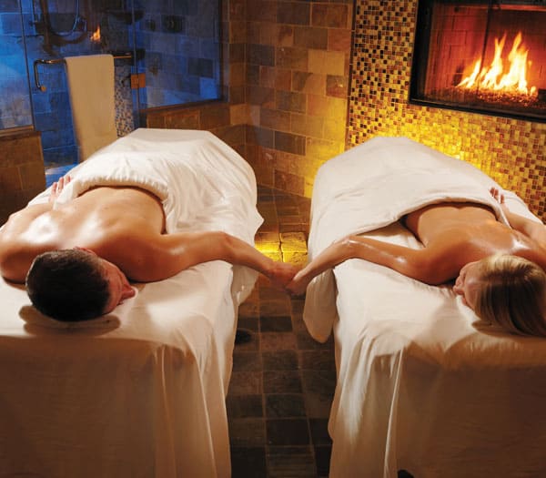 serenity spa couple getting massage by fireplace