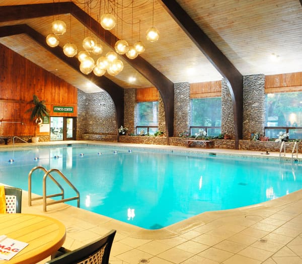indoor pool complex with high ceiling and hanging orb lights